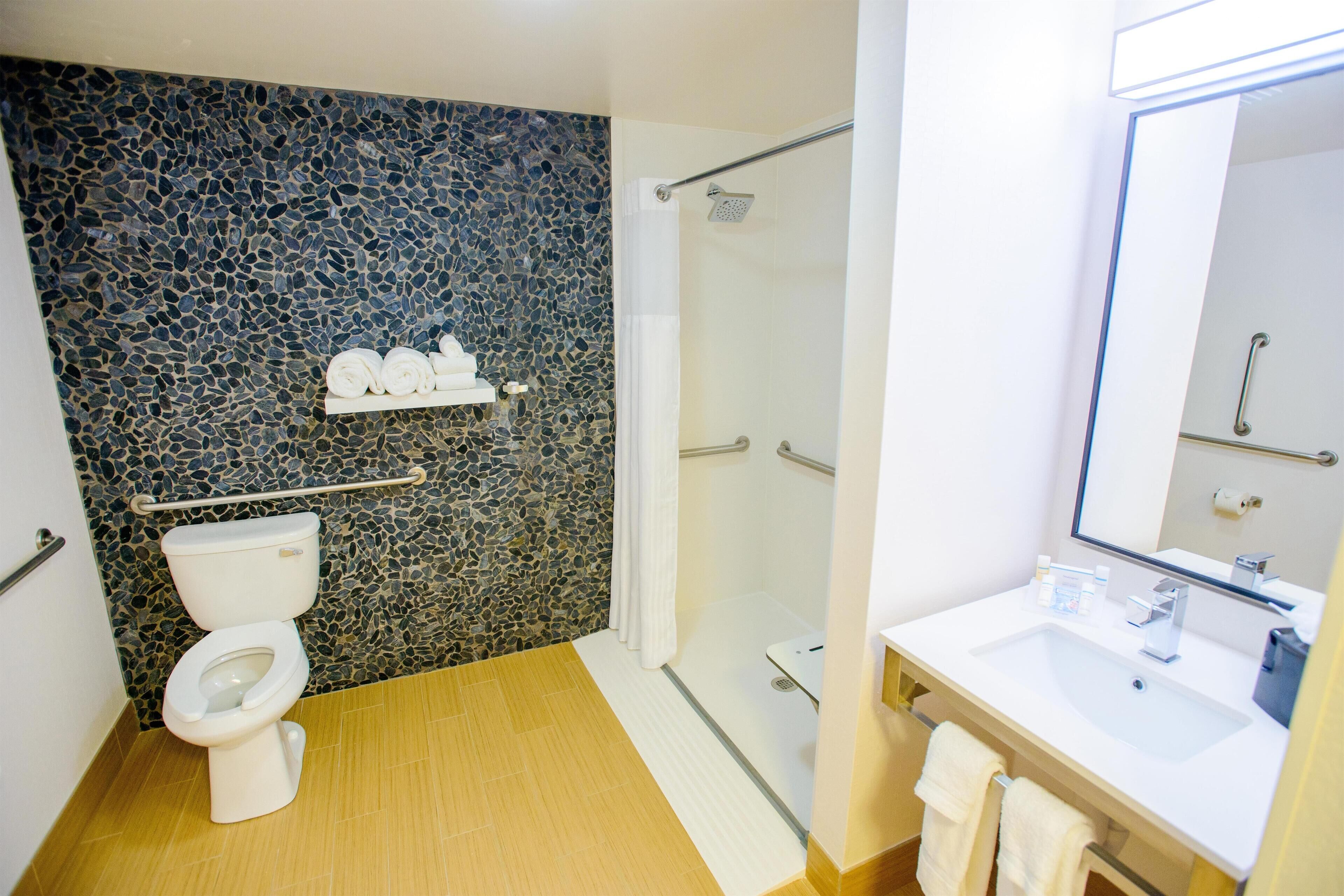 A bathroom with a toilet, a shower, and a sink.