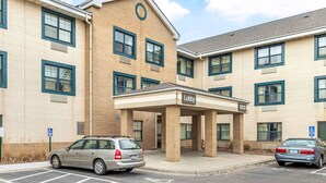 A multi-story building with a 'Lobby' sign, parking spaces, and a wheelchair-accessible sign.