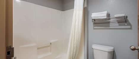 A bathroom with a shower, toilet, and towel rack.