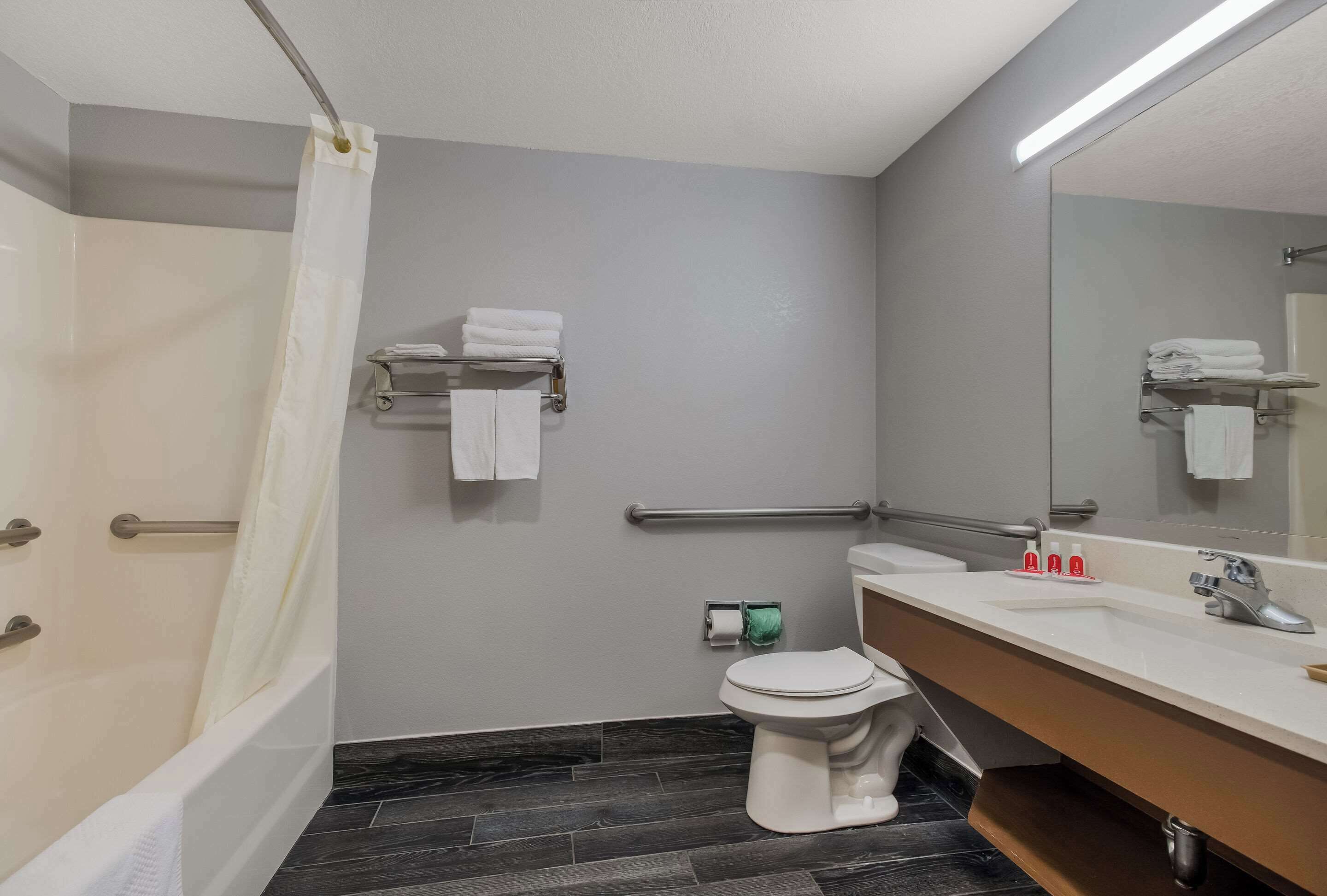 A modern bathroom with a shower, toilet, and sink.