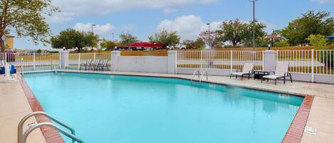 Relax by the clear pool surrounded by lounge chairs and a metal ladder for easy access.
