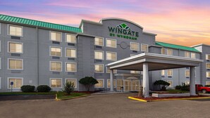 A Wingate by Wyndham hotel with a covered entrance, multiple windows, and a green roof. - Wingate by Wyndham Hattiesburg (Hattiesburg)