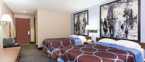 A hotel room with two beds, a desk, a TV, and artwork on the walls.