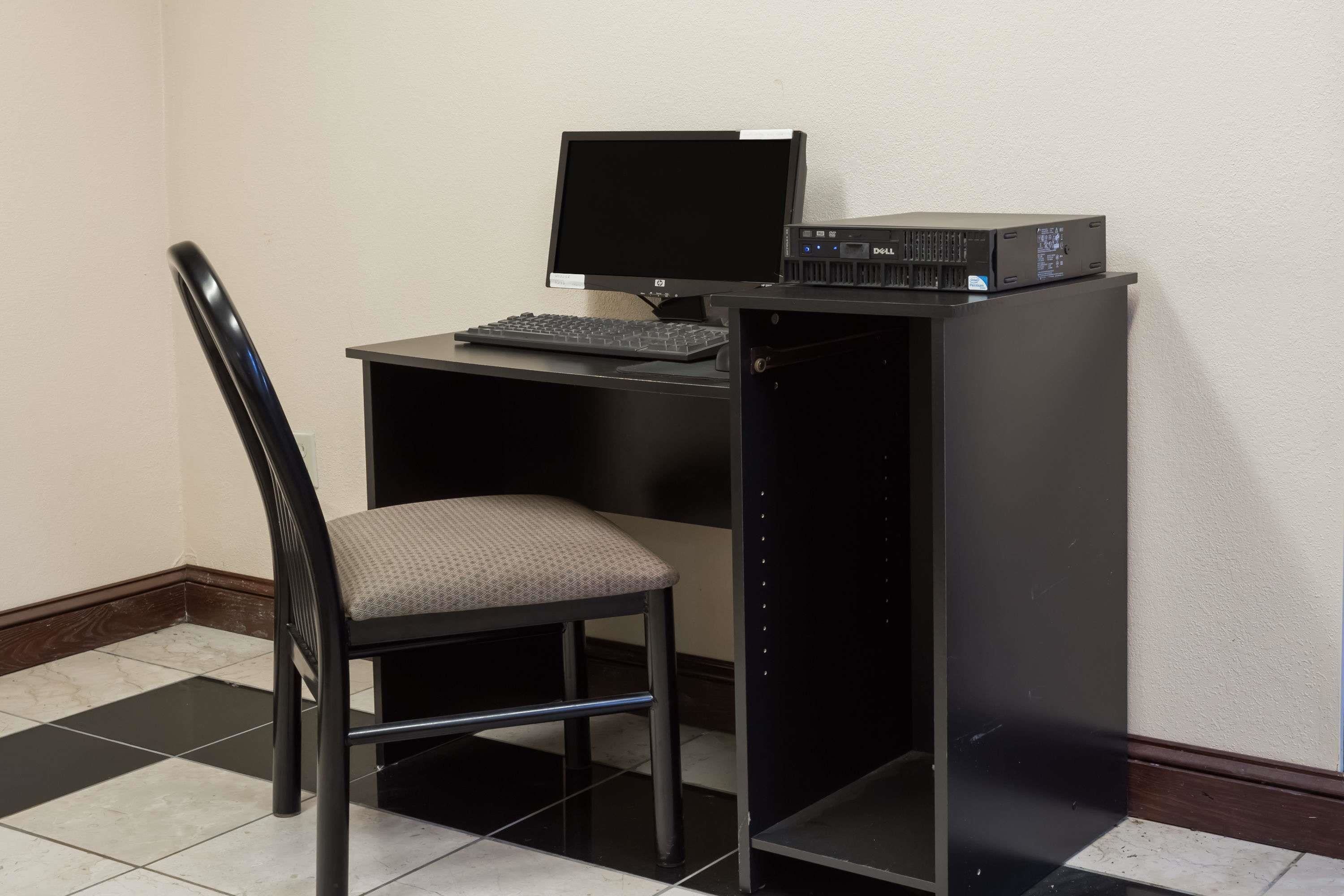 A compact workspace with a desk, a chair, a monitor, and a keyboard.