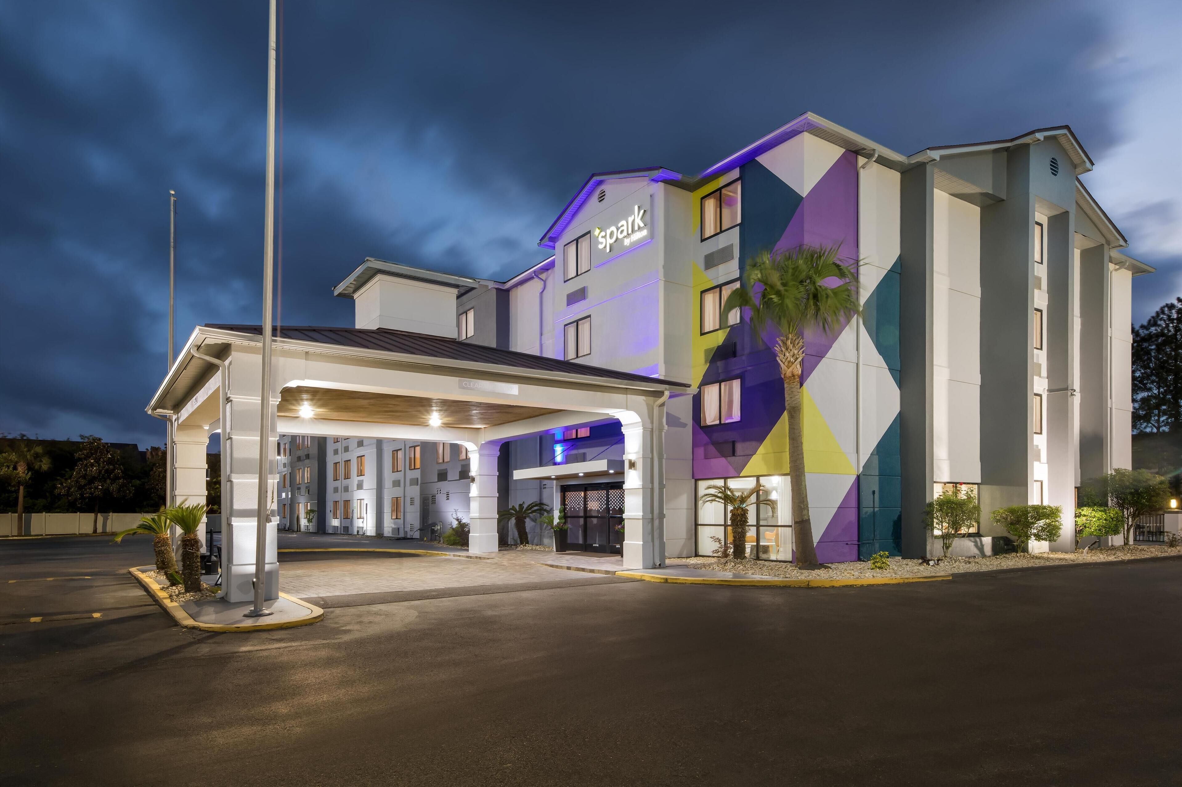 A hotel with a modern design, featuring a geometric facade and a well-lit entrance.