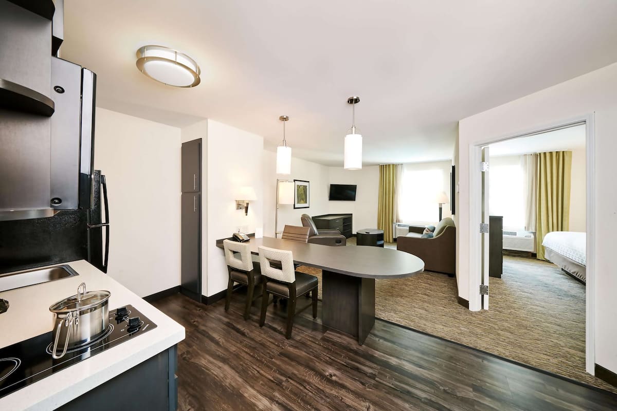 Een moderne hotelkamer met kitchenette, een eethoek en een slaapkamer.