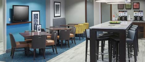 Relax in this stylish room with a dining area, bar, and seating space, featuring a flat-screen TV and convenient amenities.