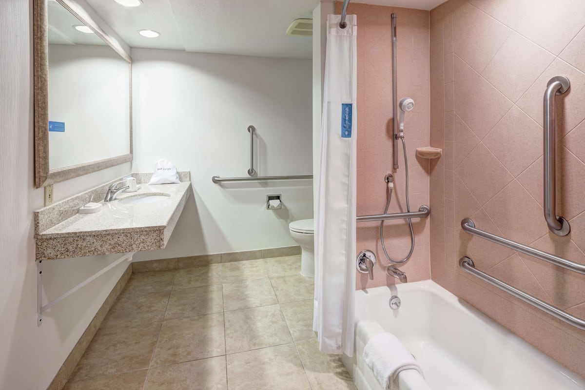 A bathroom with a sink, toilet, shower, and bathtub.
