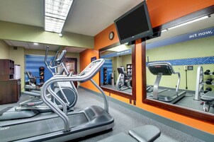 A gym with treadmills, exercise bikes, and a mirrored wall with motivational text.