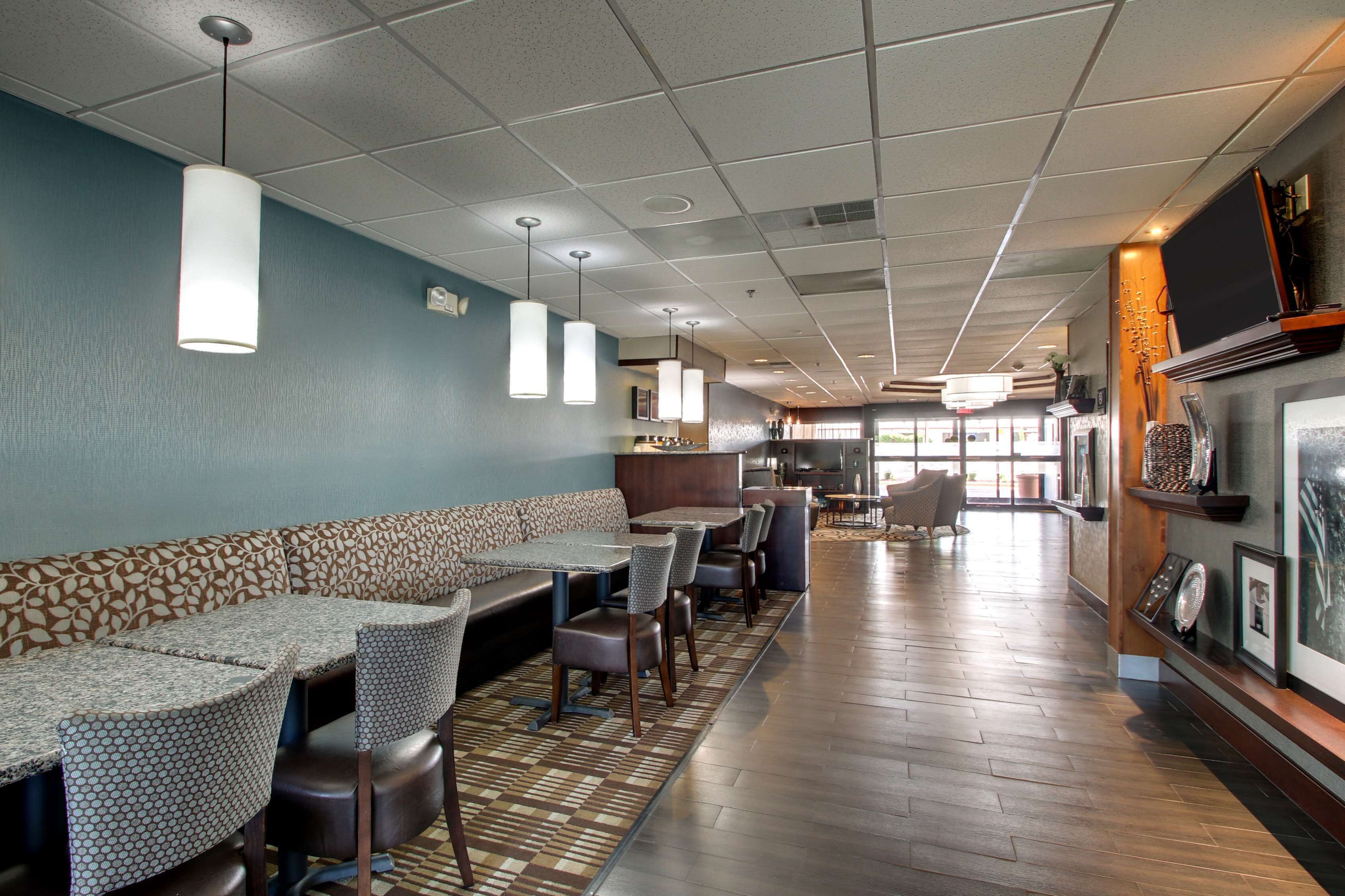 A restaurant with a long counter, booths, and a bar area.