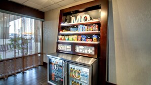 A vending machine with snacks and a refrigerated display with bottled water and soda.