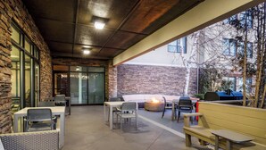 An outdoor patio with stone walls, a fire pit, and seating areas. - Holiday Inn Express Hotel & Suites Bozeman West by IHG (Bozeman)