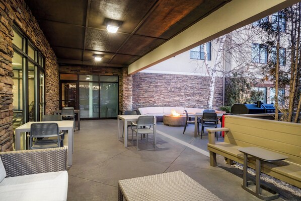 An outdoor patio with stone walls, a fire pit, and seating areas. - Holiday Inn Express Hotel & Suites Bozeman West by IHG (Bozeman)