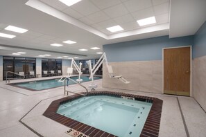 A swimming pool area with a hot tub, lounge chairs, and a door. - Holiday Inn Express Hotel & Suites Bozeman West by IHG (Bozeman)