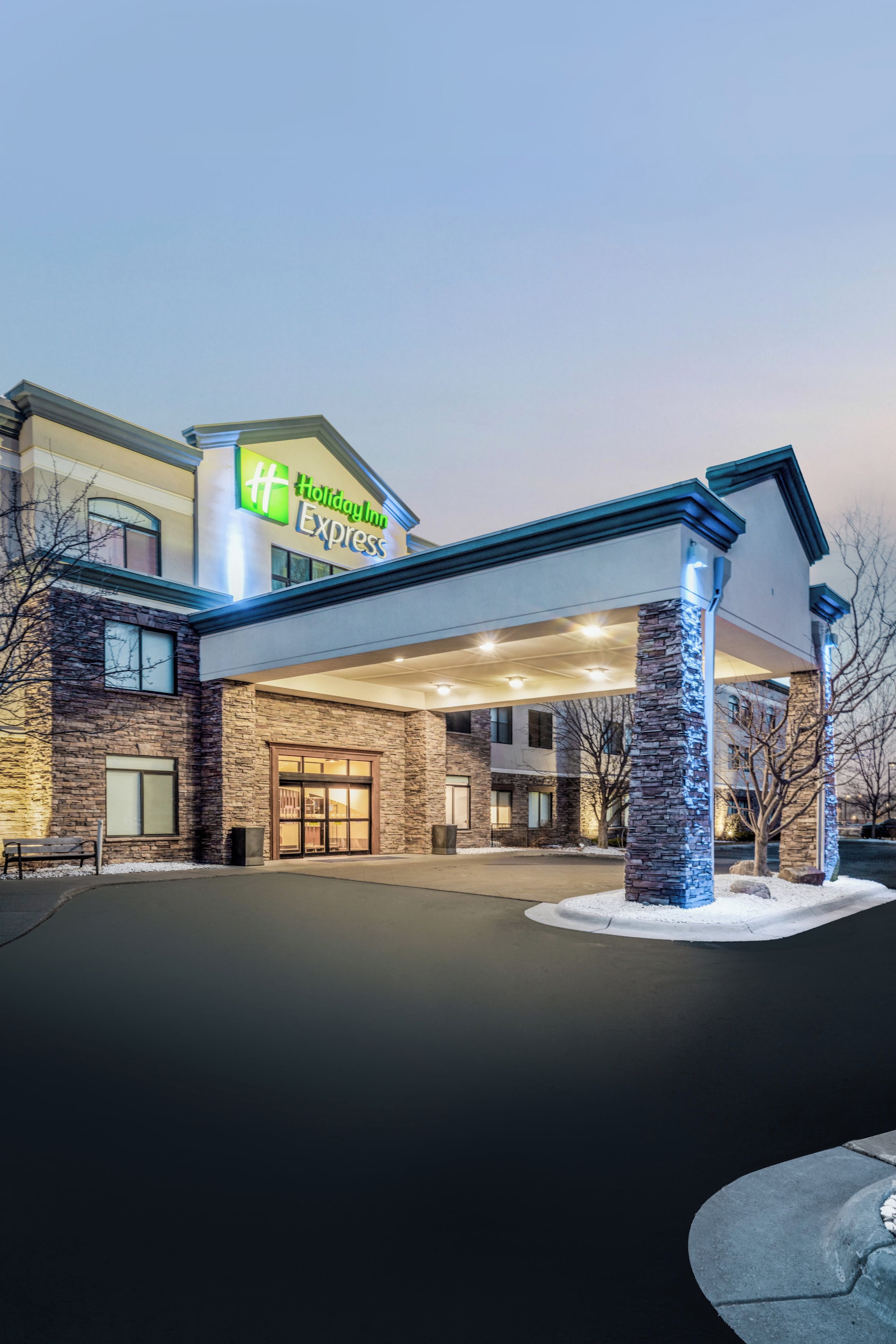A Holiday Inn Express hotel with a modern design, featuring a prominent entrance and a well-lit facade.
