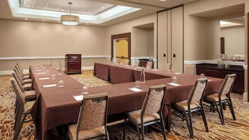 Une salle de conférence équipée d’une longue table, de chaises et d’un coin cuisine.