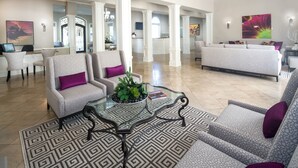 Amplio salón con diseño moderno, que incluye una mesa de centro de cristal, alfombra estampada y muebles contemporáneos.