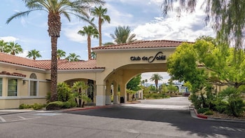 A well-maintained courtyard with a putting green, surrounded by mature trees and a building with balconies. at Club De Soleil All-Suite Resort