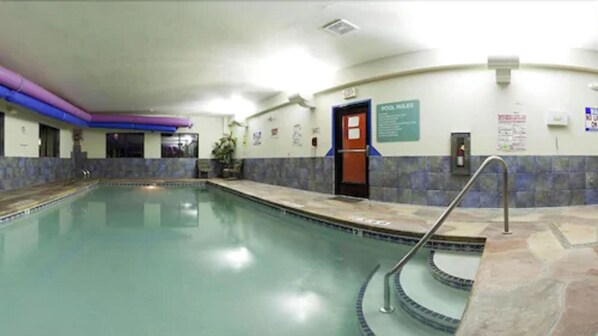 A swimming pool with a tiled deck and a pool rule sign. - Holiday Inn Express Hotel & Suites Raton by IHG (Raton)