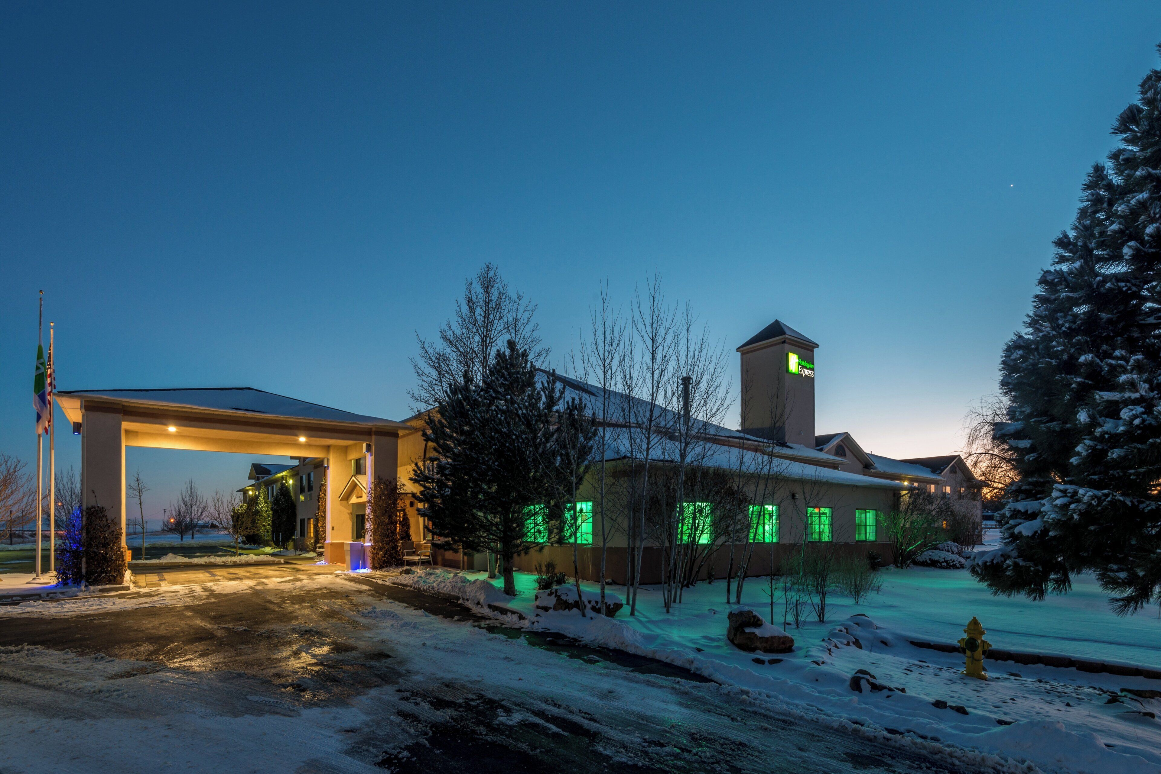 A hotel with a gas station, snow-covered landscape, and a prominent tower.