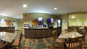 A hotel lobby with a central bar area, multiple seating arrangements, and a carpeted floor. - Holiday Inn Express Hotel & Suites Raton by IHG (Raton)