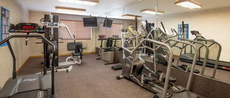 A gym with various exercise equipment, including treadmills, elliptical machines, and weight machines.
