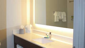 A bathroom with a white sink, a mirror, and a towel rack.