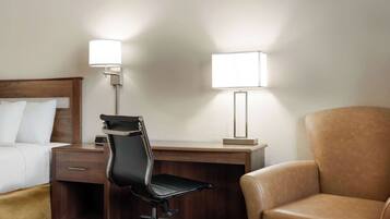Relax in a stylishly designed room with a comfortable bed, a desk for work, and a cozy reading chair.