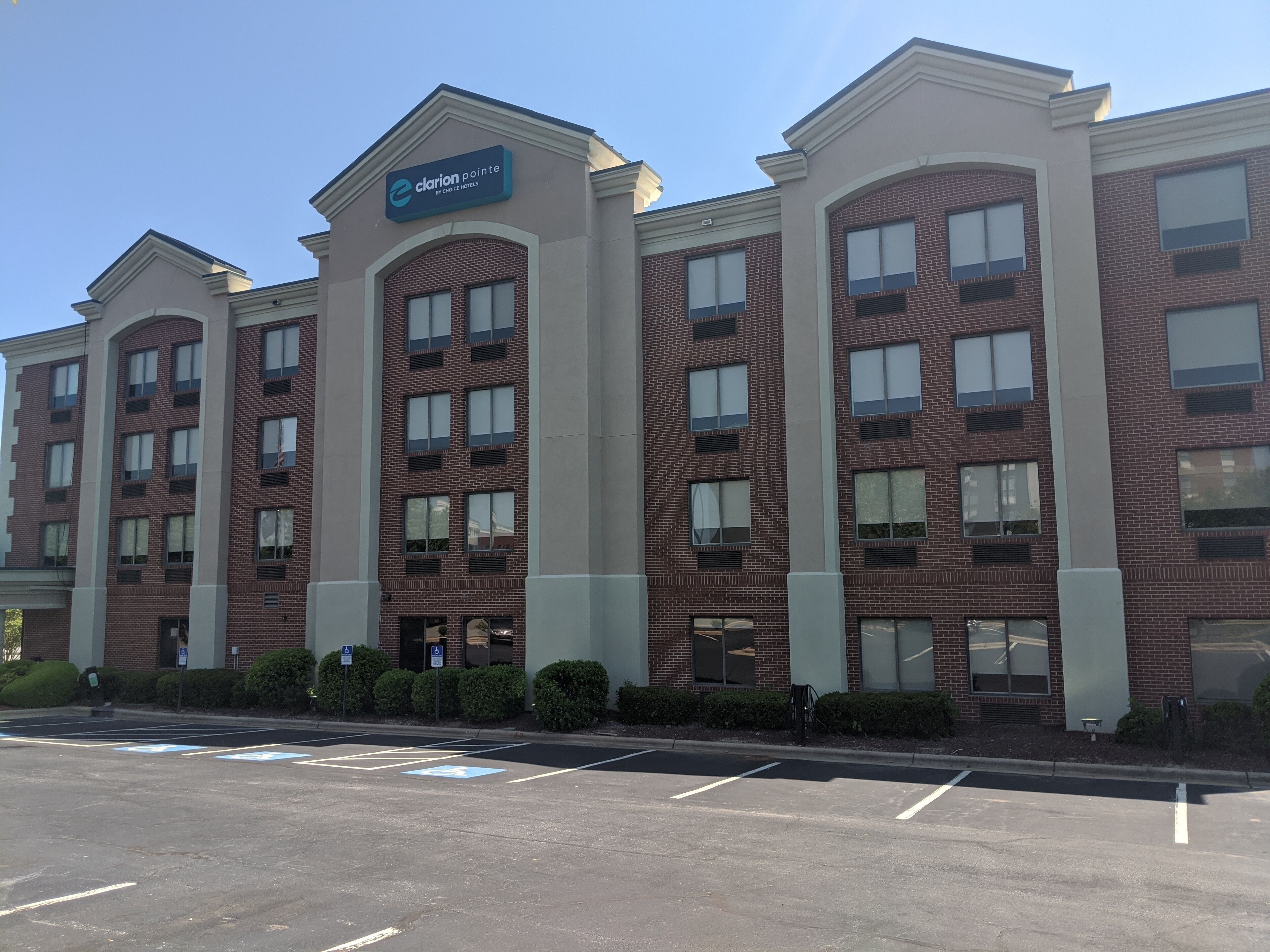A Clarion Pointe hotel with a brick facade, multiple windows, and a sign indicating it is by Choice Hotels.