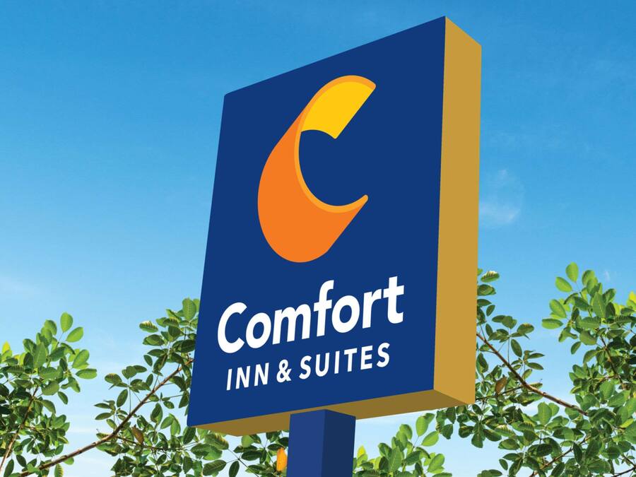 A sign for Comfort Inn & Suites with a blue background and a stylized orange 'C'.