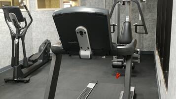 Une salle de sport équipée d’un vélo d’appartement, d’un appareil elliptique et d’un tapis de course.