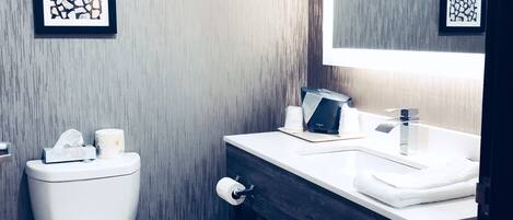 Une salle de bain moderne avec des toilettes, un lavabo et un miroir.