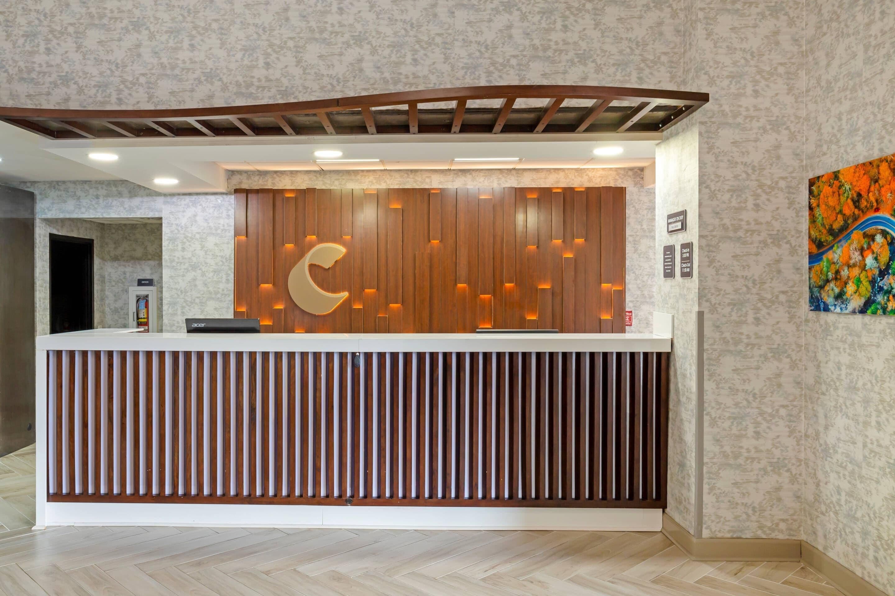 Un mostrador de recepción con diseño de paneles de madera y el logotipo de una luna creciente.