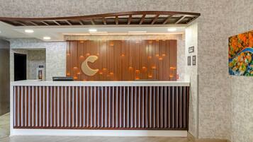 Un mostrador de recepción con diseño de paneles de madera y el logotipo de una luna creciente.