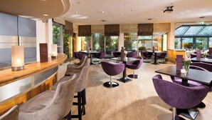 A modern restaurant with a wooden bar and purple chairs.