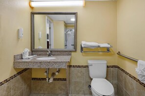 A bathroom with a sink, mirror, toilet, and towel rack.