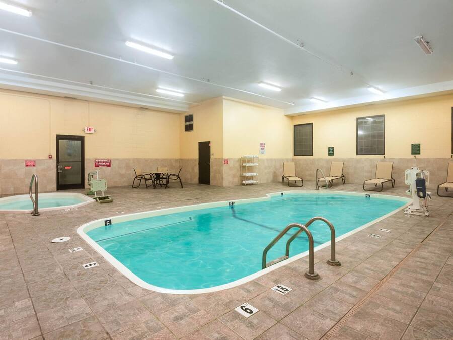 An indoor swimming pool with multiple lanes, marked lanes, and safety railings.