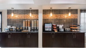 Una cocina moderna con dos islas, máquinas de café y una variedad de alimentos.