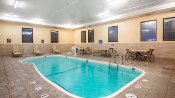 Una piscina techada, sillones reclinables de piscina