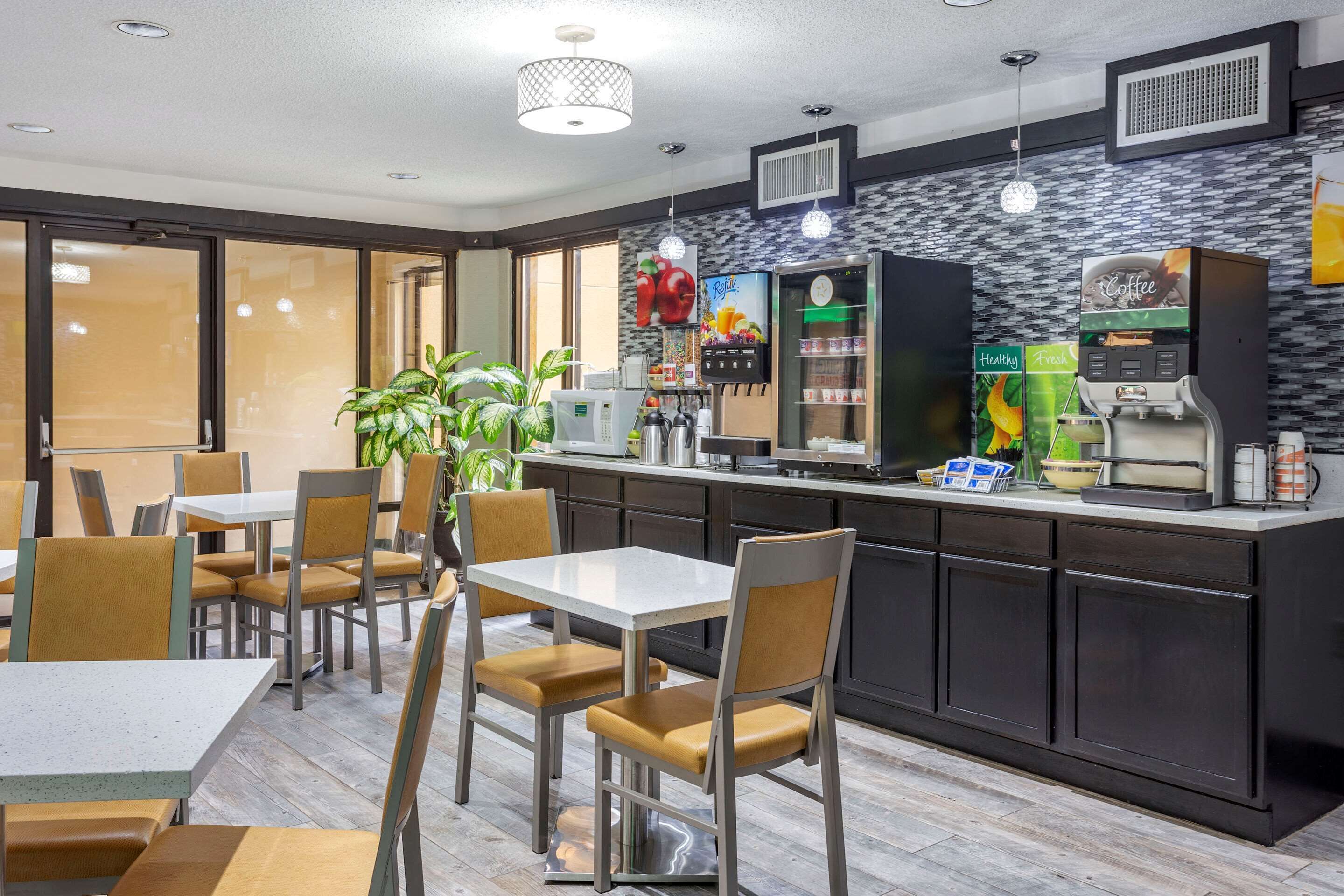 Un café moderne doté d’un bar, de tables et de chaises, ainsi que d’une machine à café.