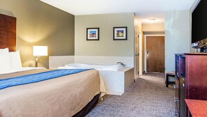 A hotel room with a large bed, a separate bathroom with a bathtub, a desk, and a television. - Comfort Inn Atlanta Downtown South (Atlanta)