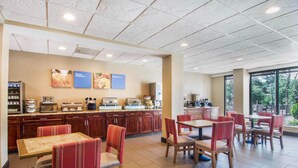 A breakfast area with a buffet setup, seating arrangements, and a view of the outdoors. - Comfort Inn Atlanta Downtown South (Atlanta)