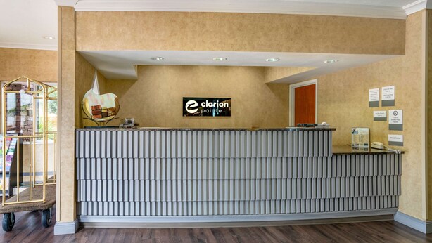 A reception desk with a 'Clarion Pointe' sign, a bulletin board, and a phone. - Clarion Pointe Medford (Medford)