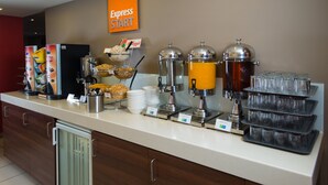 A buffet setup with various food items, beverage dispensers, and a sign indicating 'Express Start'.