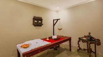 Cozy retreat with a traditional bed, decorative table, and wall-mounted shelf.