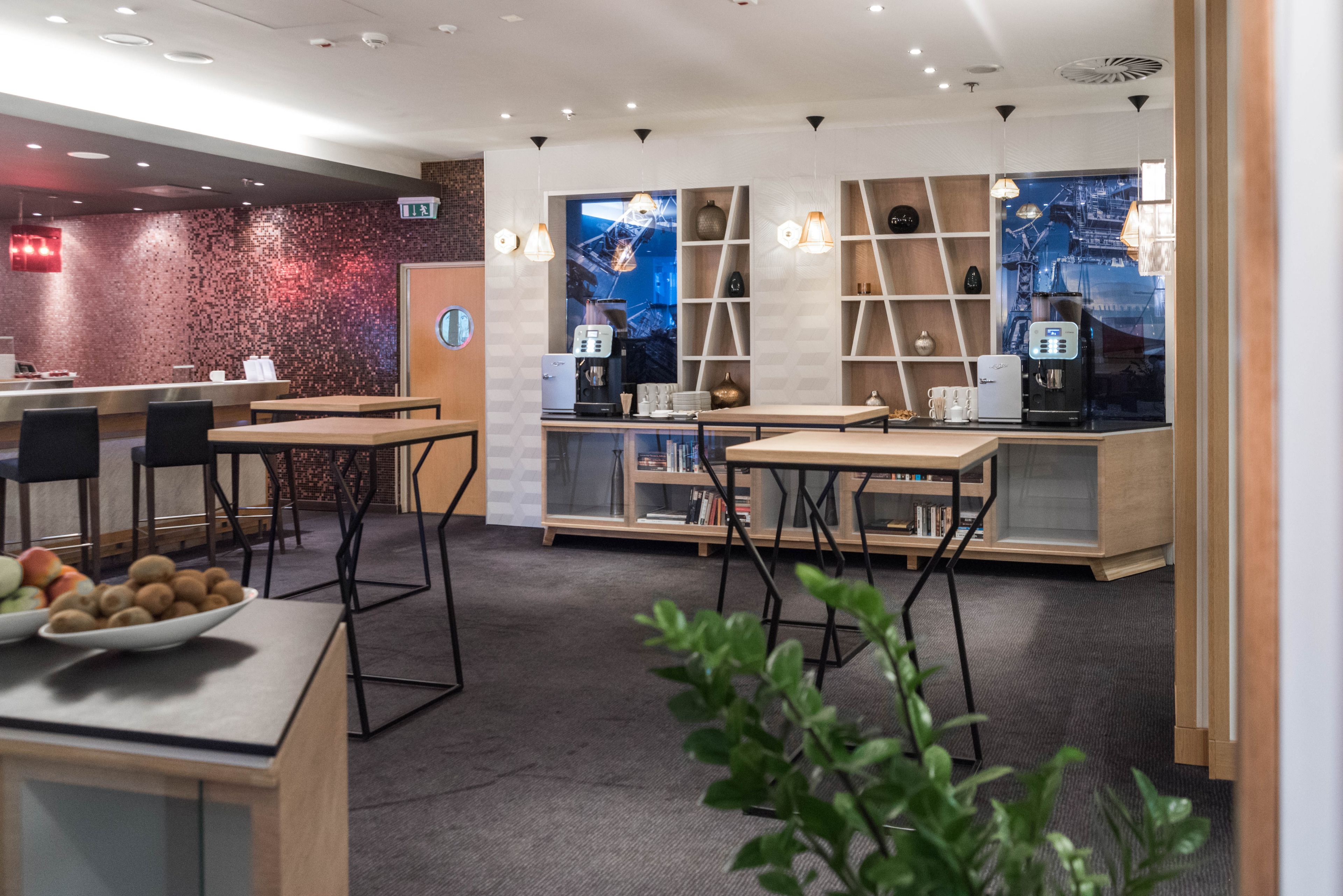 A modern cafe with a bar area, seating, and a coffee machine.
