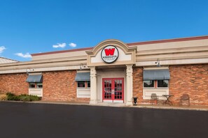 A building with a prominent 'W' logo, brick facade, and a red door. - Best Western St. Catharines Hotel & Conference Centre (St. Catharines)