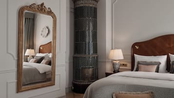 Camera da letto con un grande specchio decorativo, un'imponente colonna decorativa, una testiera in legno e un letto con molti cuscini.