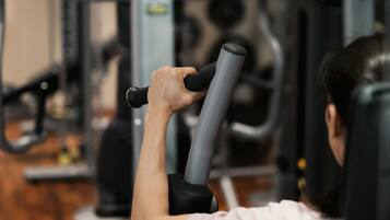 A gym with exercise equipment, including a seated row machine and a leg press.