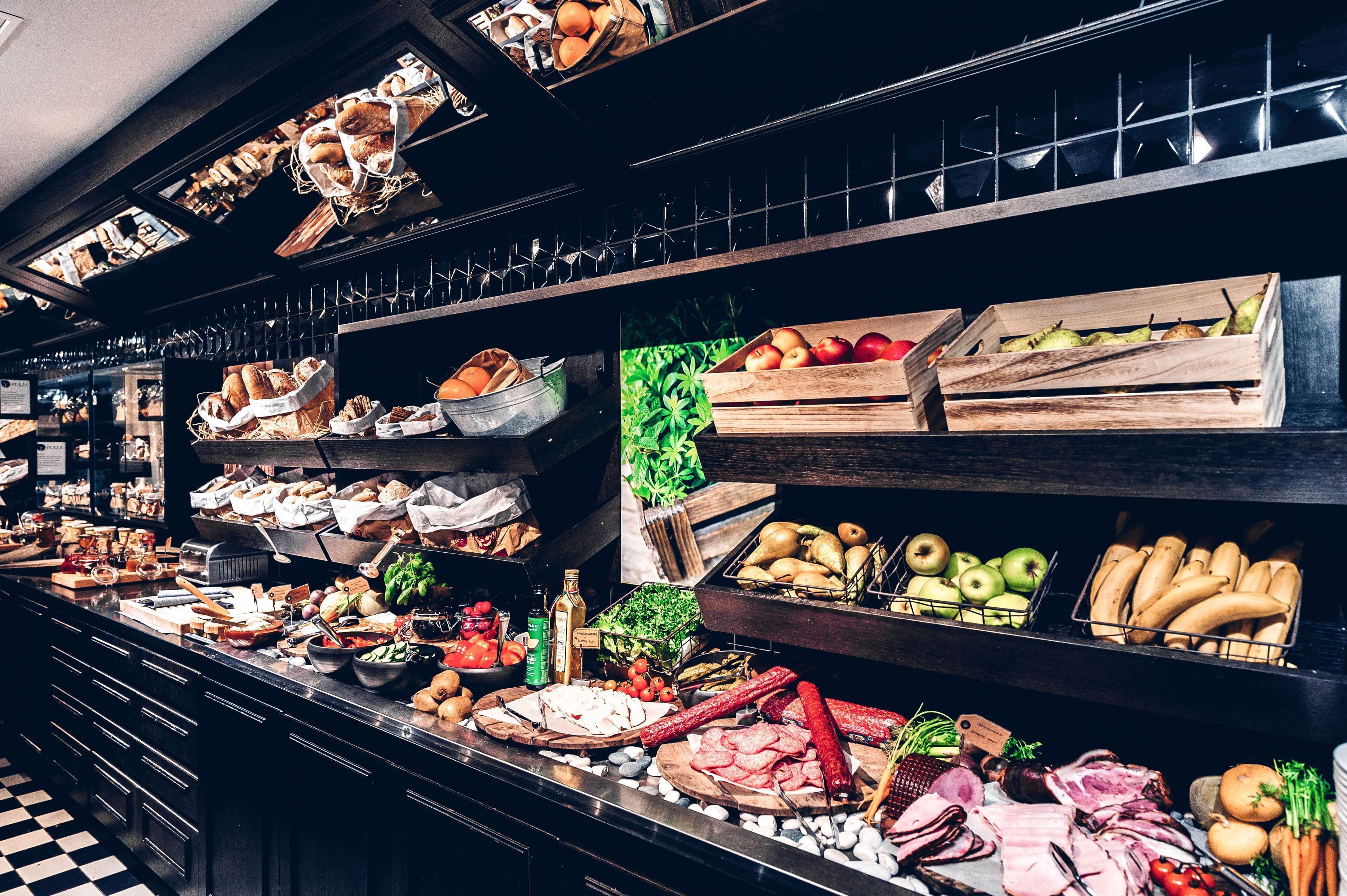 Un bufé con diversos alimentos, como frutas, verduras, carnes y panes.